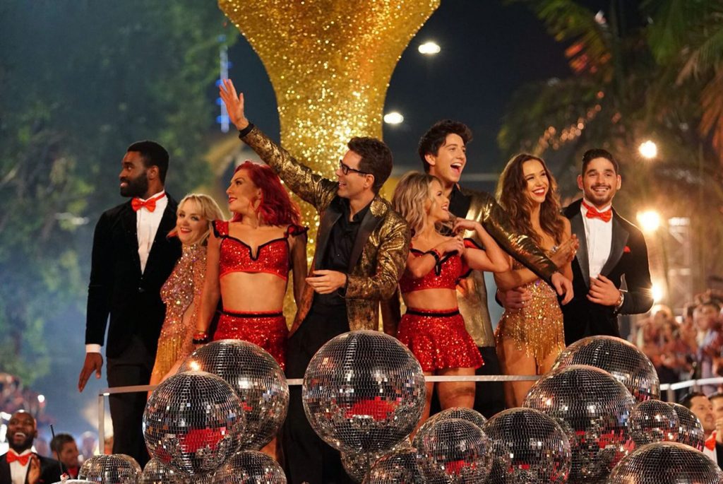 A group of people standing in front of a crowd posing for the camera
